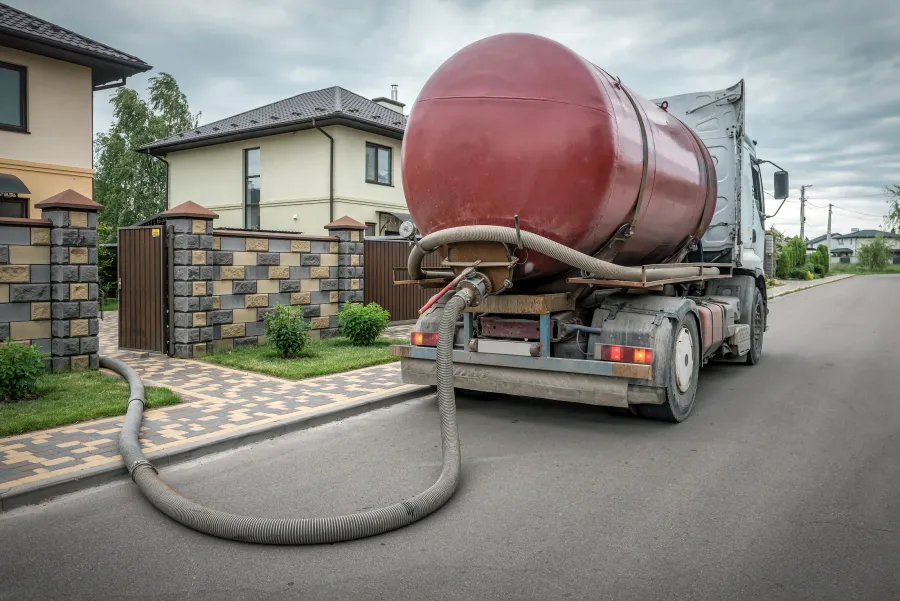 Septic pumping service truck parked at a residential property, illustrating the type of service this site helps you find